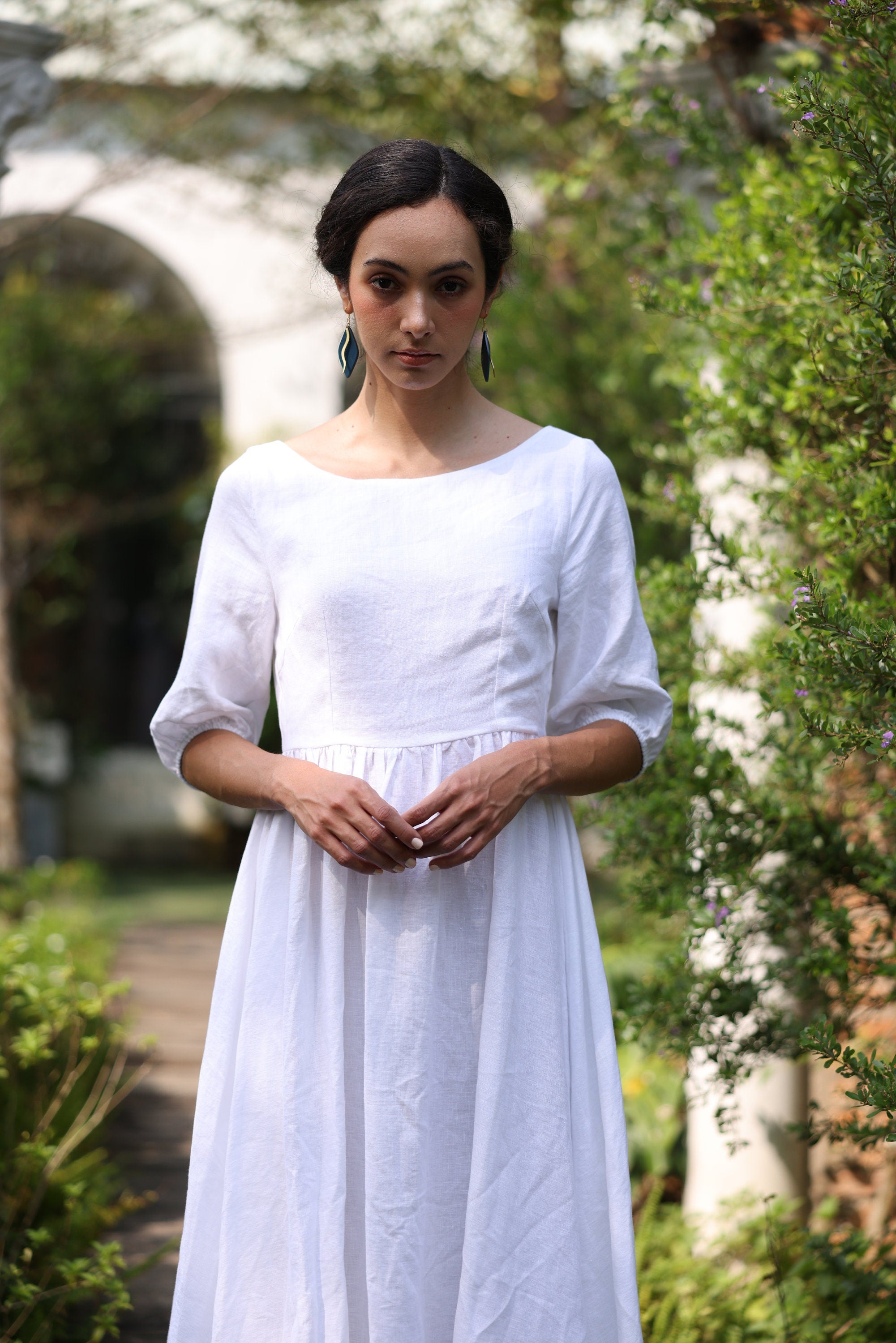 Woman wearing a white dress standing in a garden