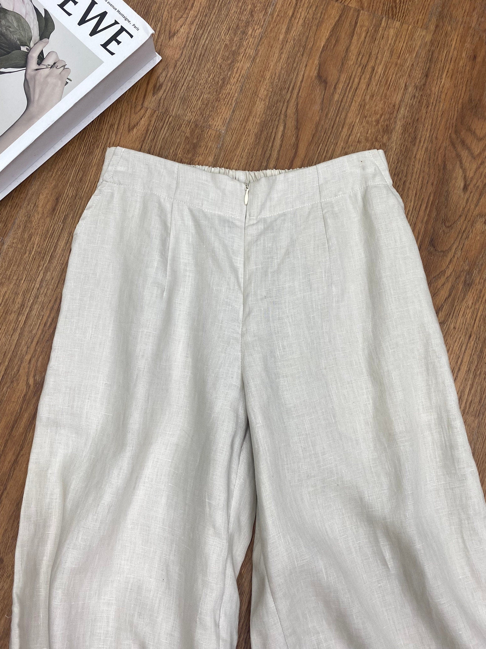 Light-colored pants on a wooden surface with a magazine underneath