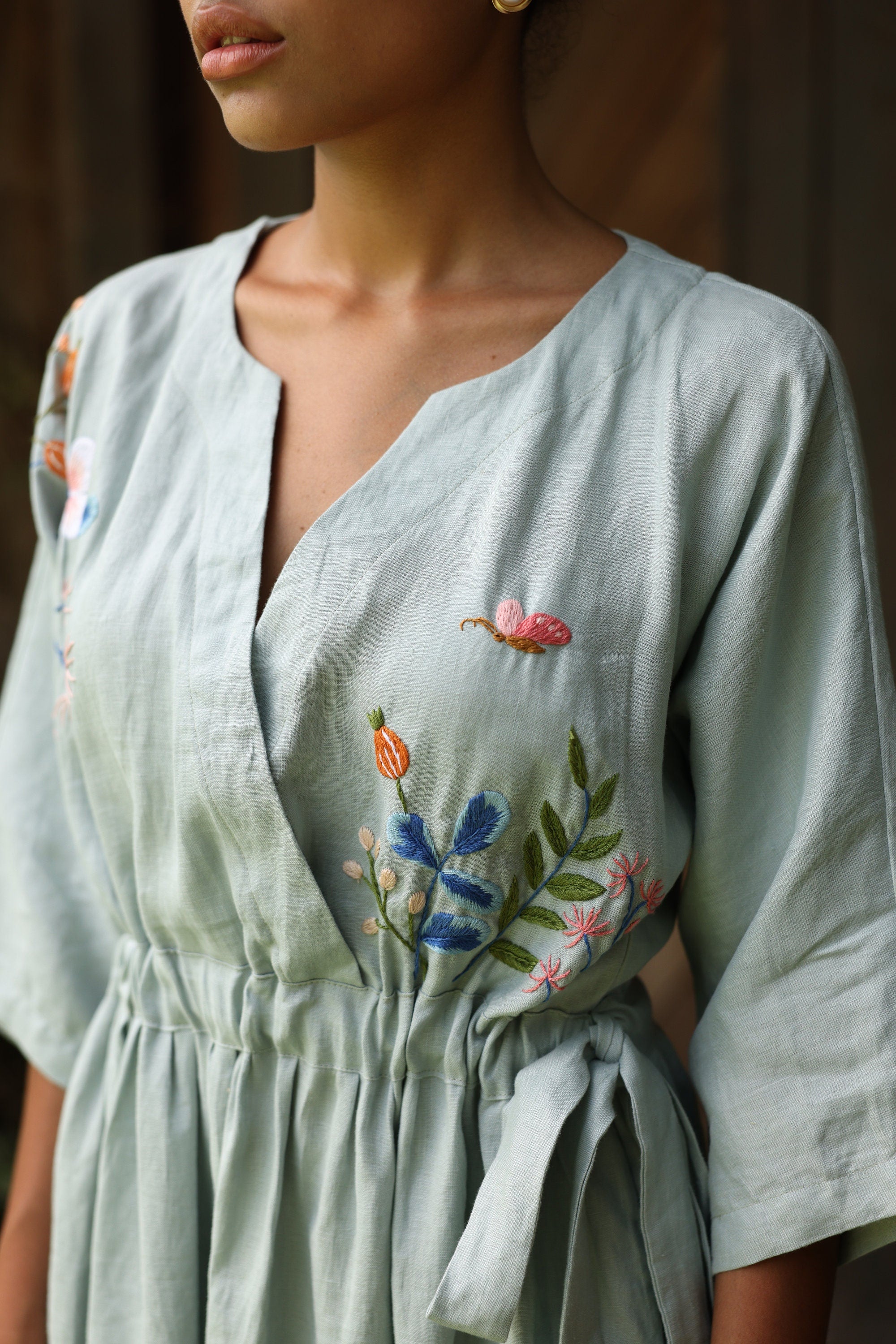 Light blue dress with floral embroidery on a blurred background