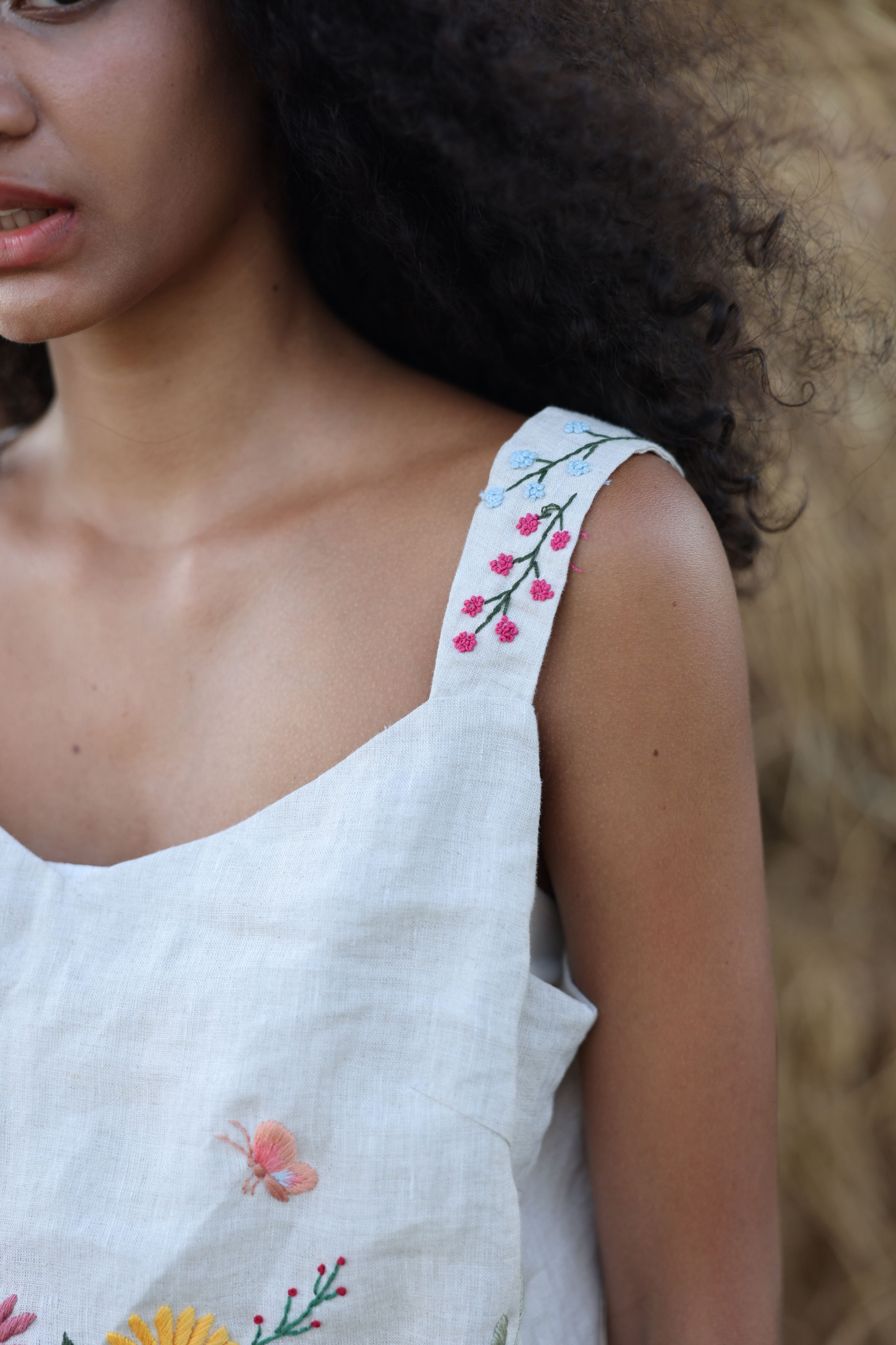 Woman wearing a top with floral embroidery, blurred background