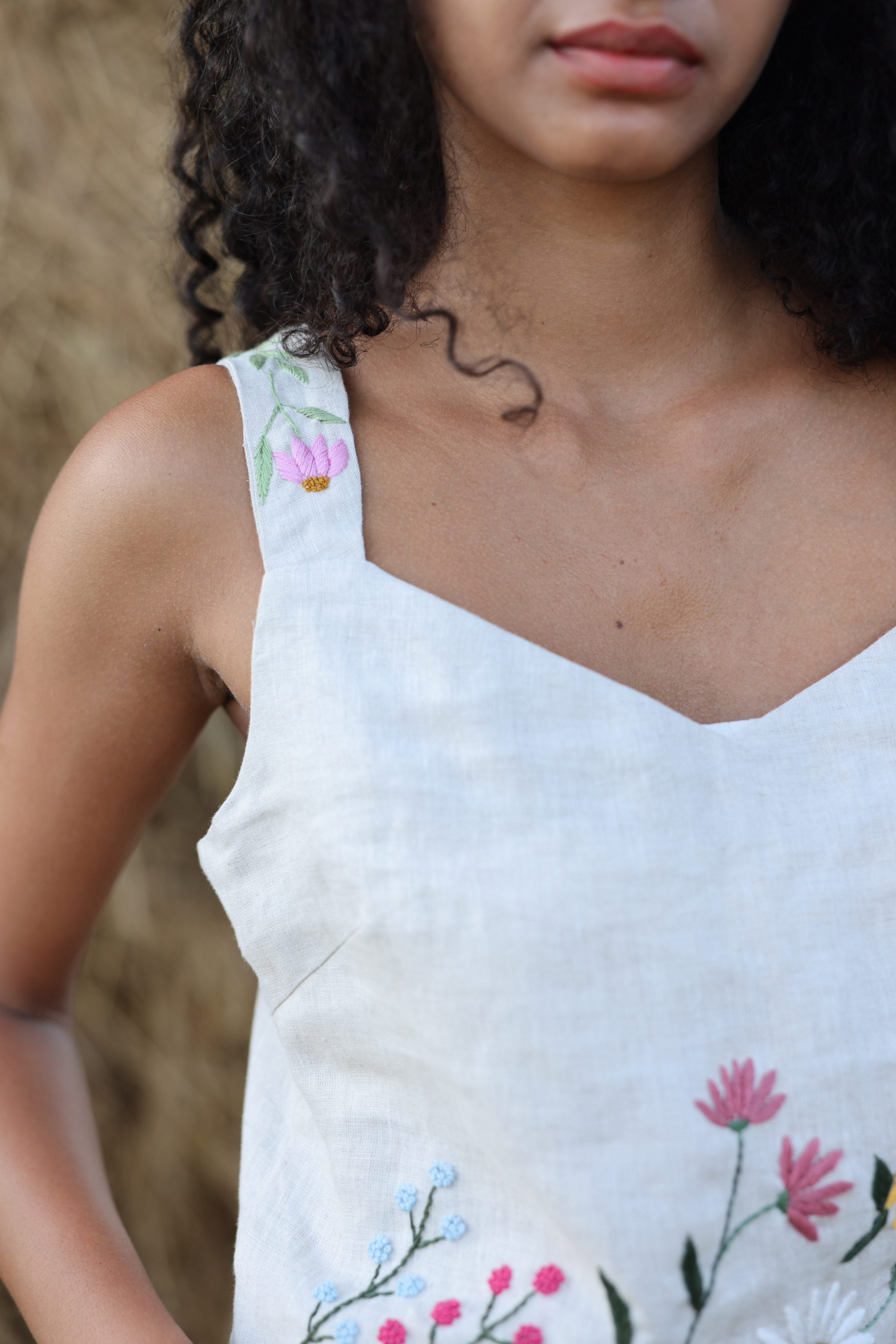Sleeveless top with floral embroidery on a blurred background