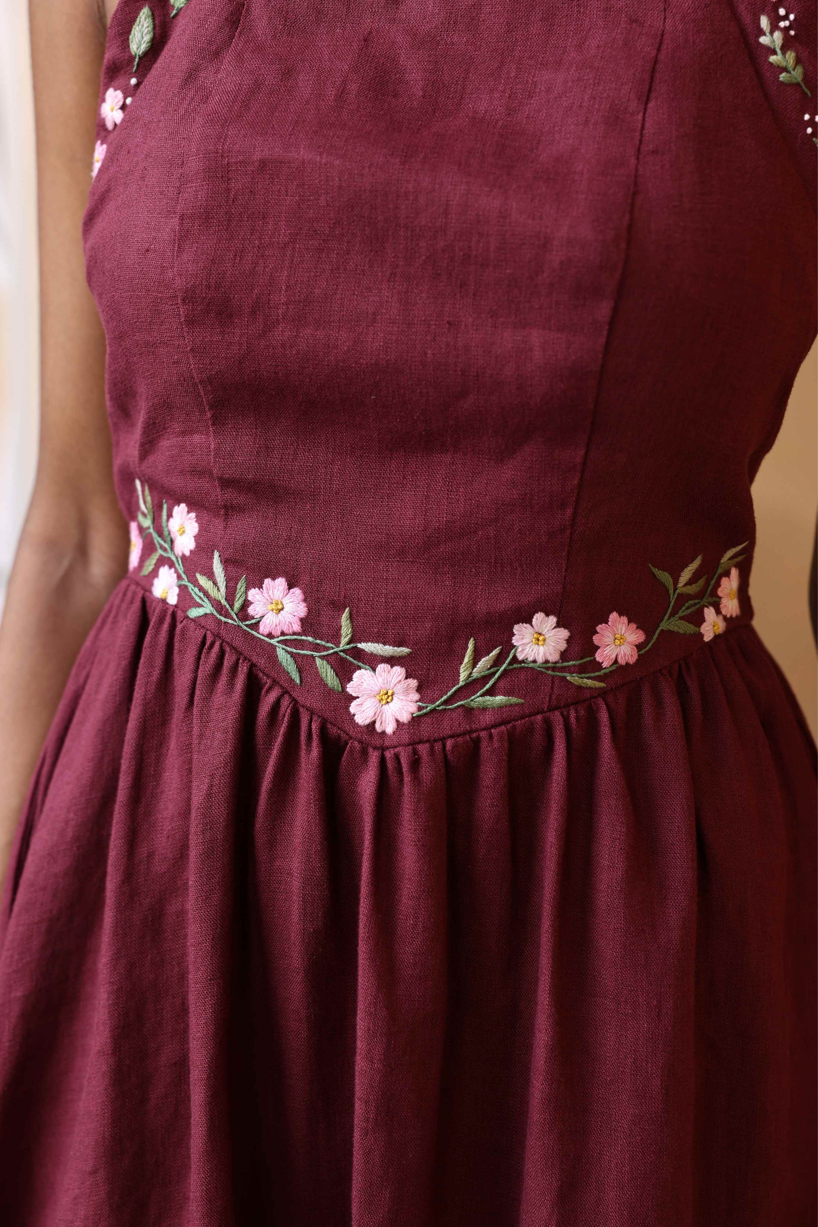 A dress with floral embroidery on a plain background