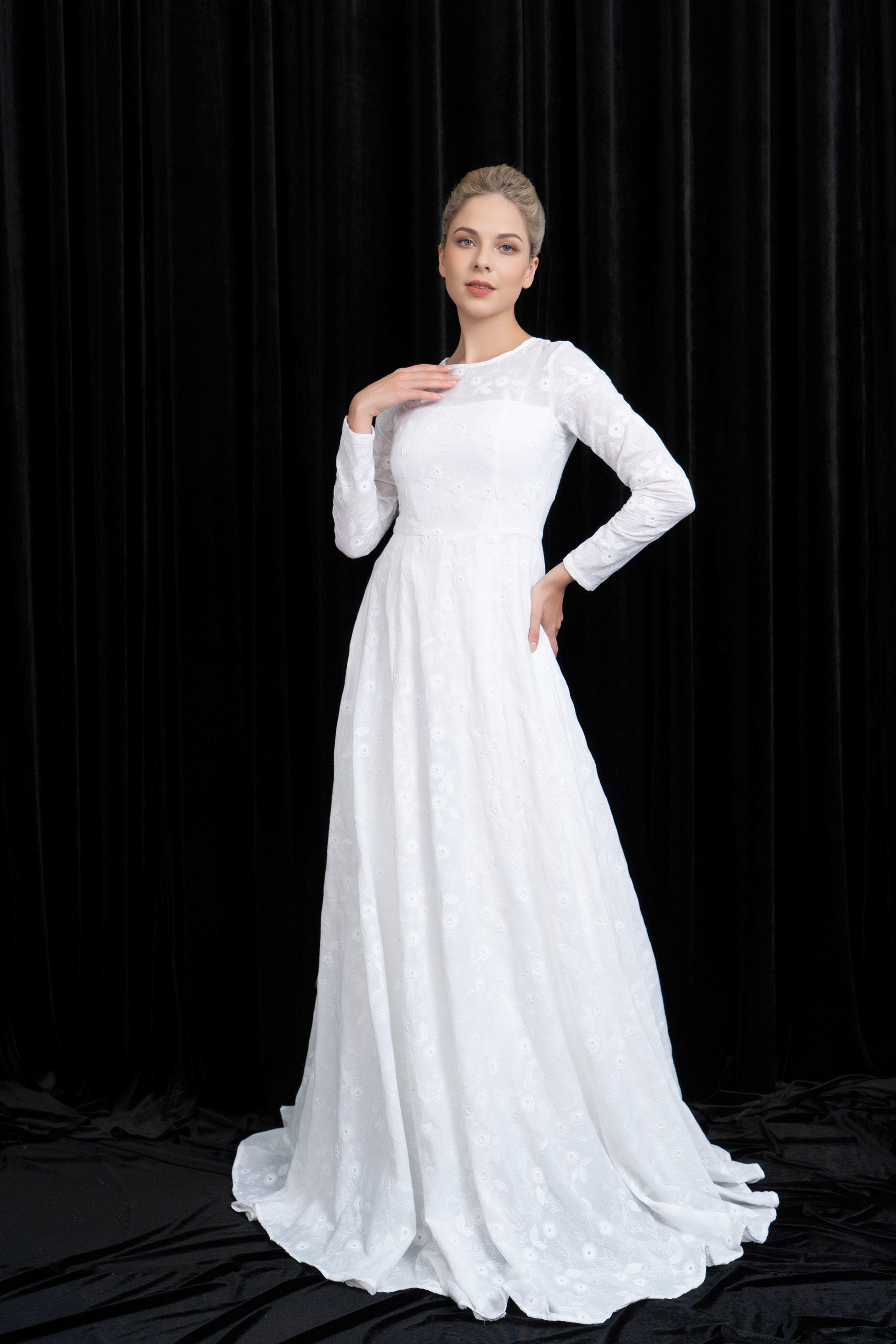 Woman wearing a white wedding dress against a black background