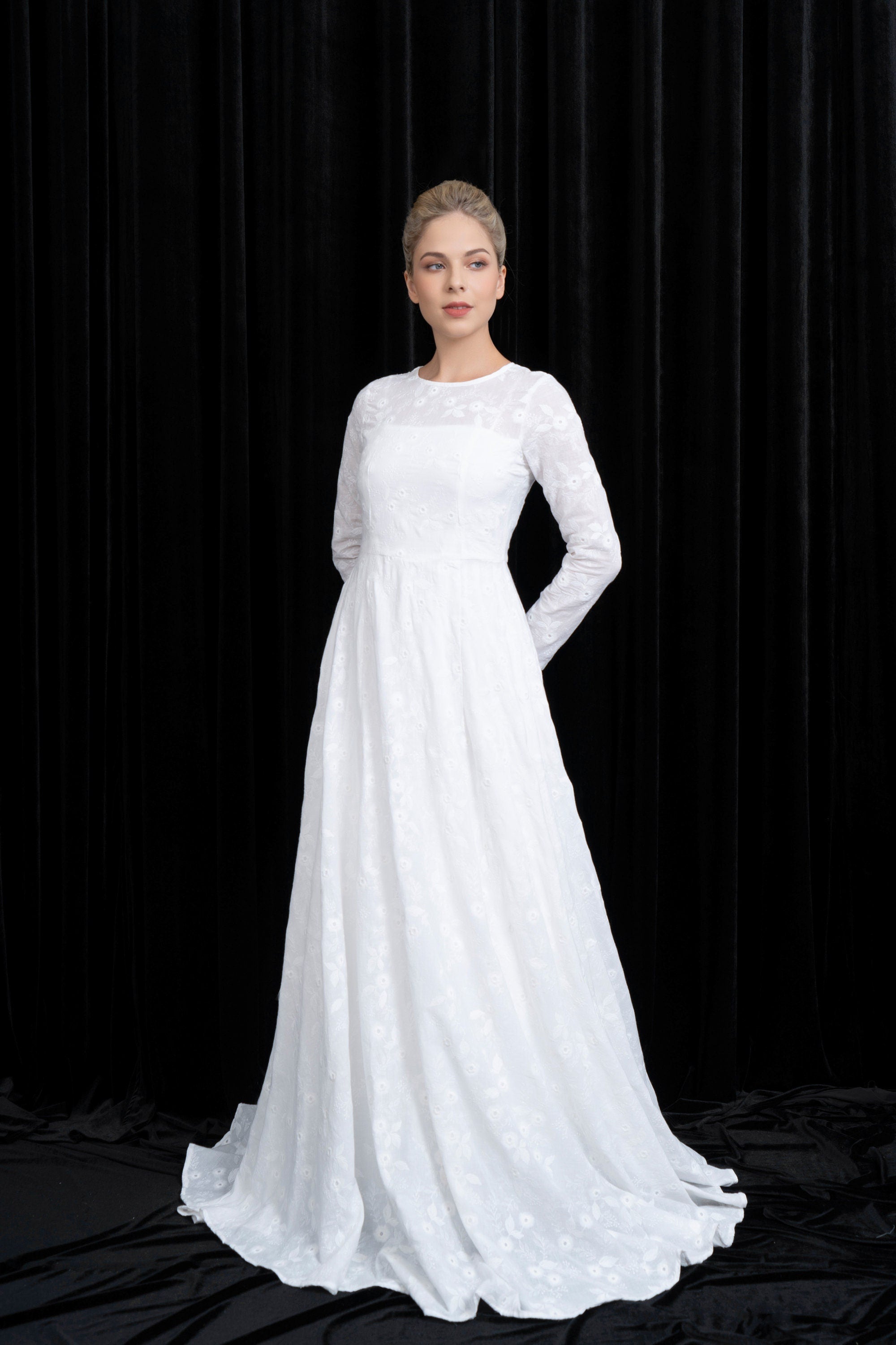 Woman wearing a white wedding dress against a black background
