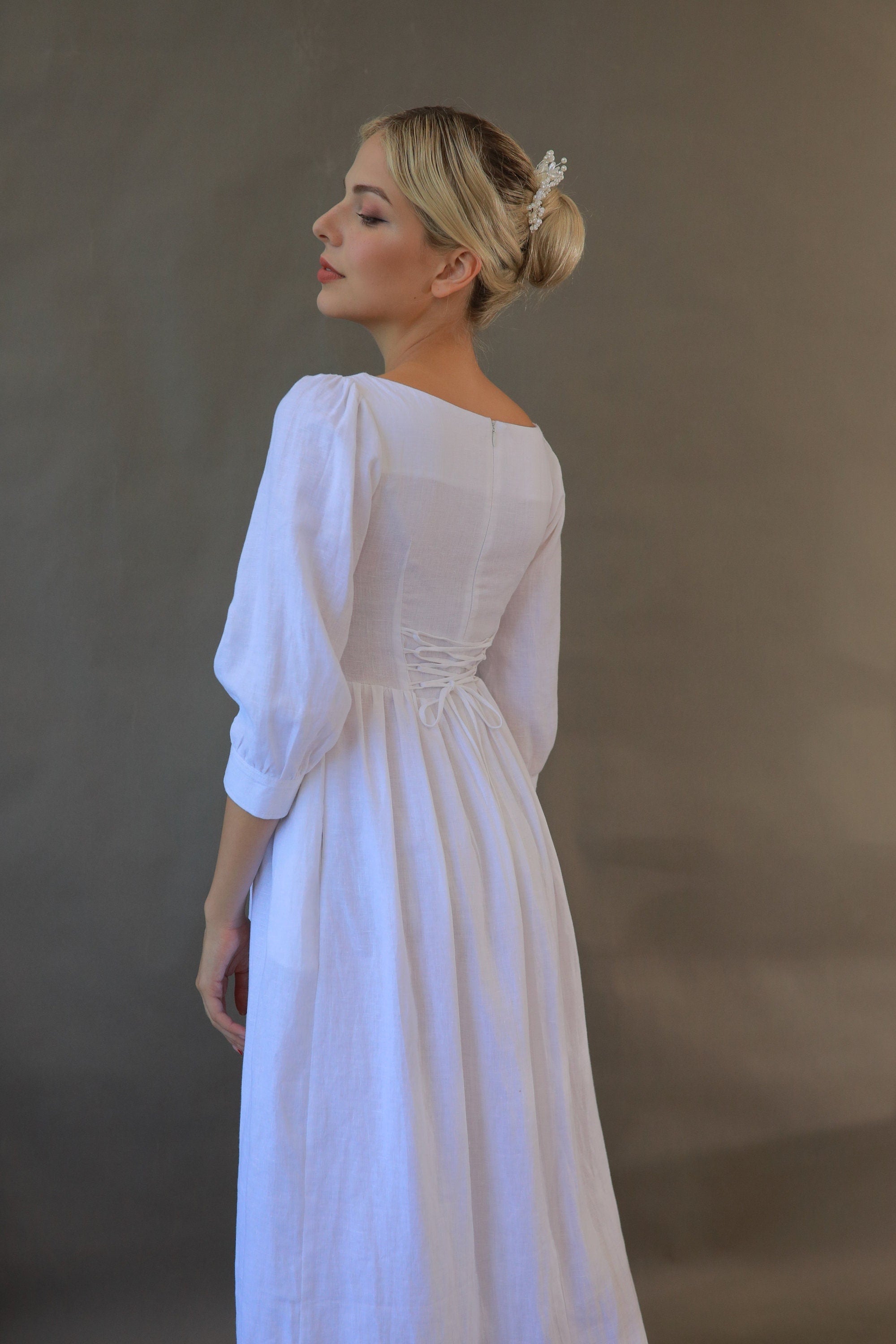 Woman wearing a white dress against a plain background