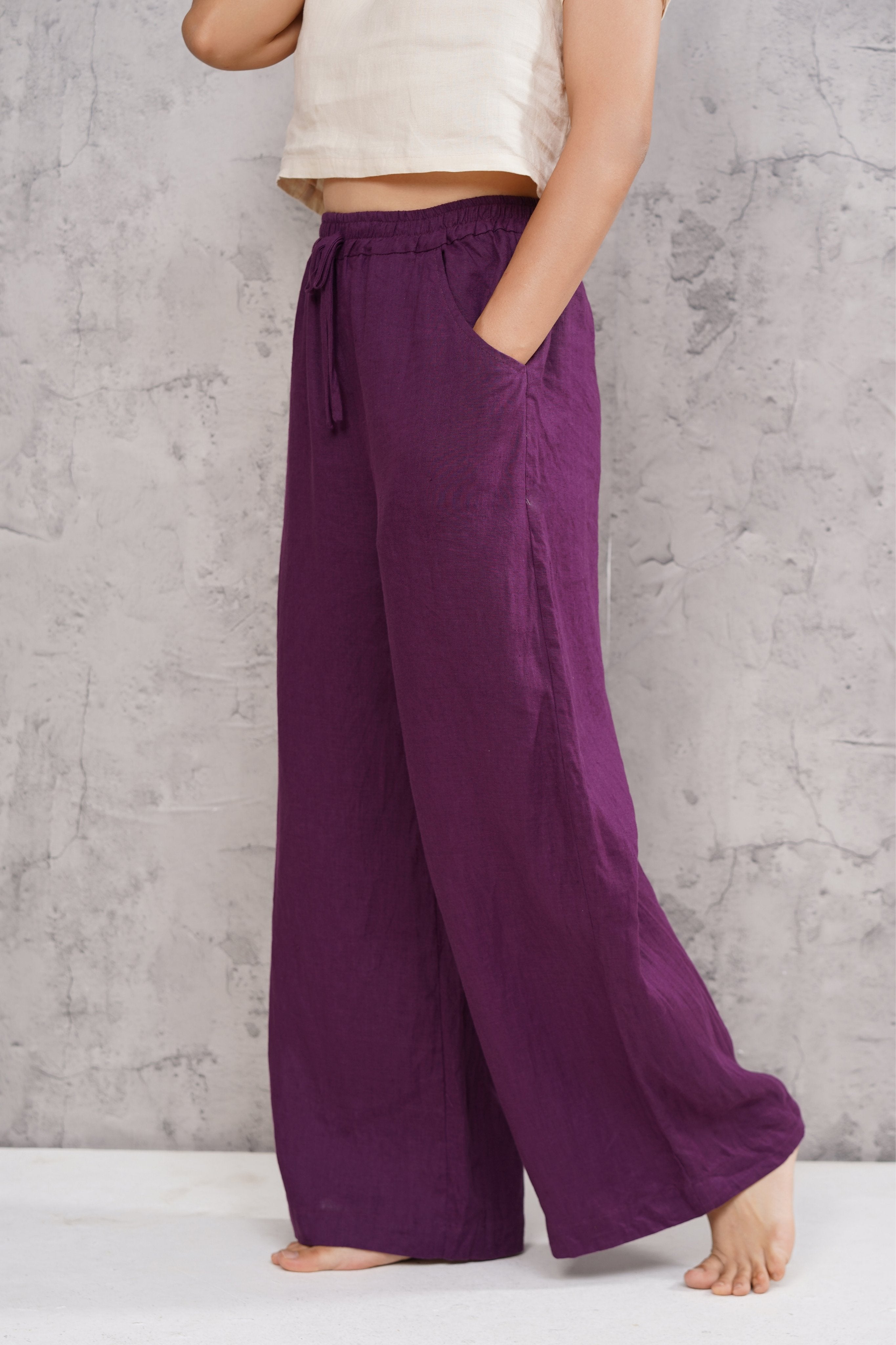Person wearing purple wide-leg pants with a neutral background