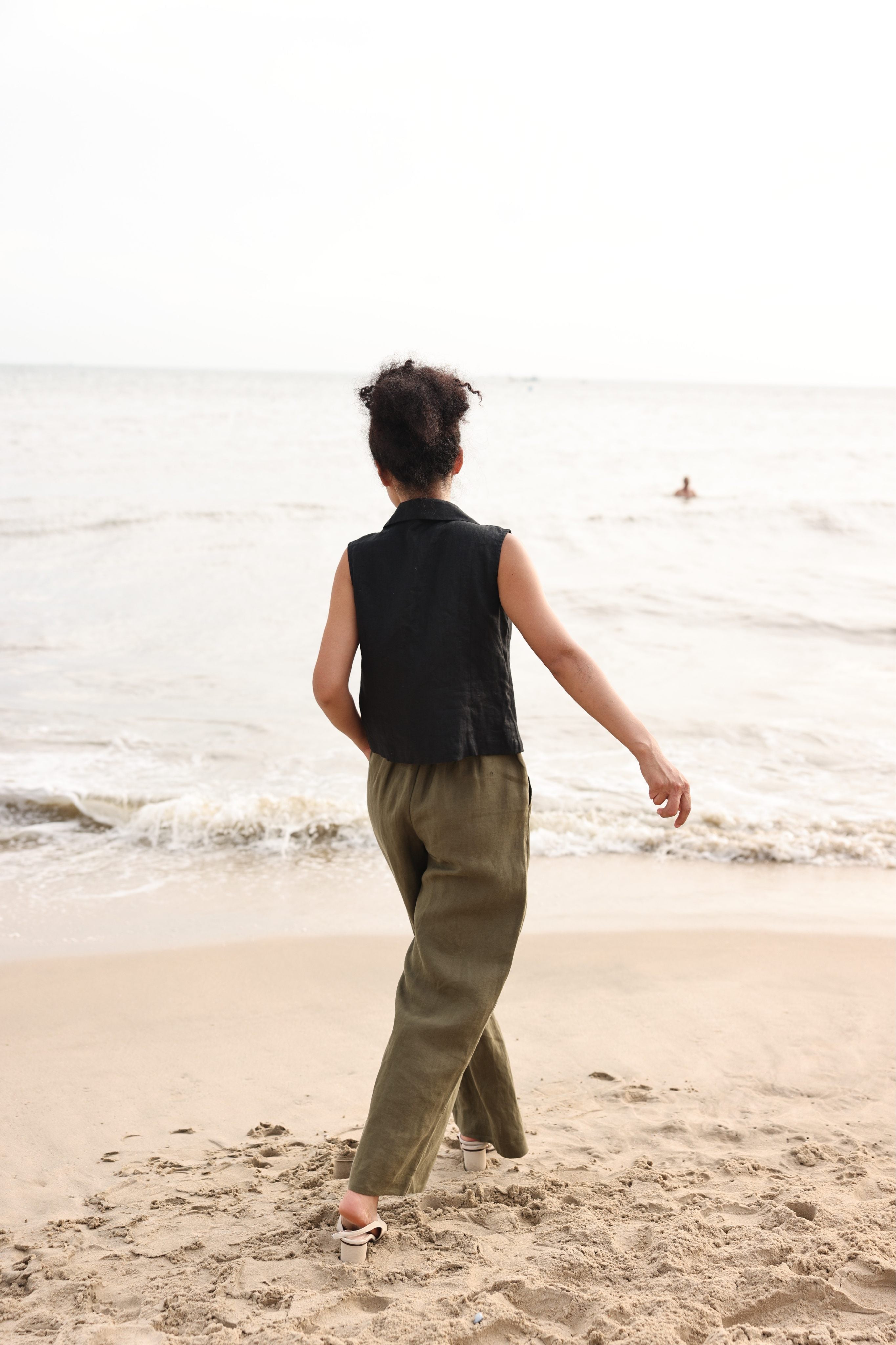 Person walking on a beach with ocean waves in the background