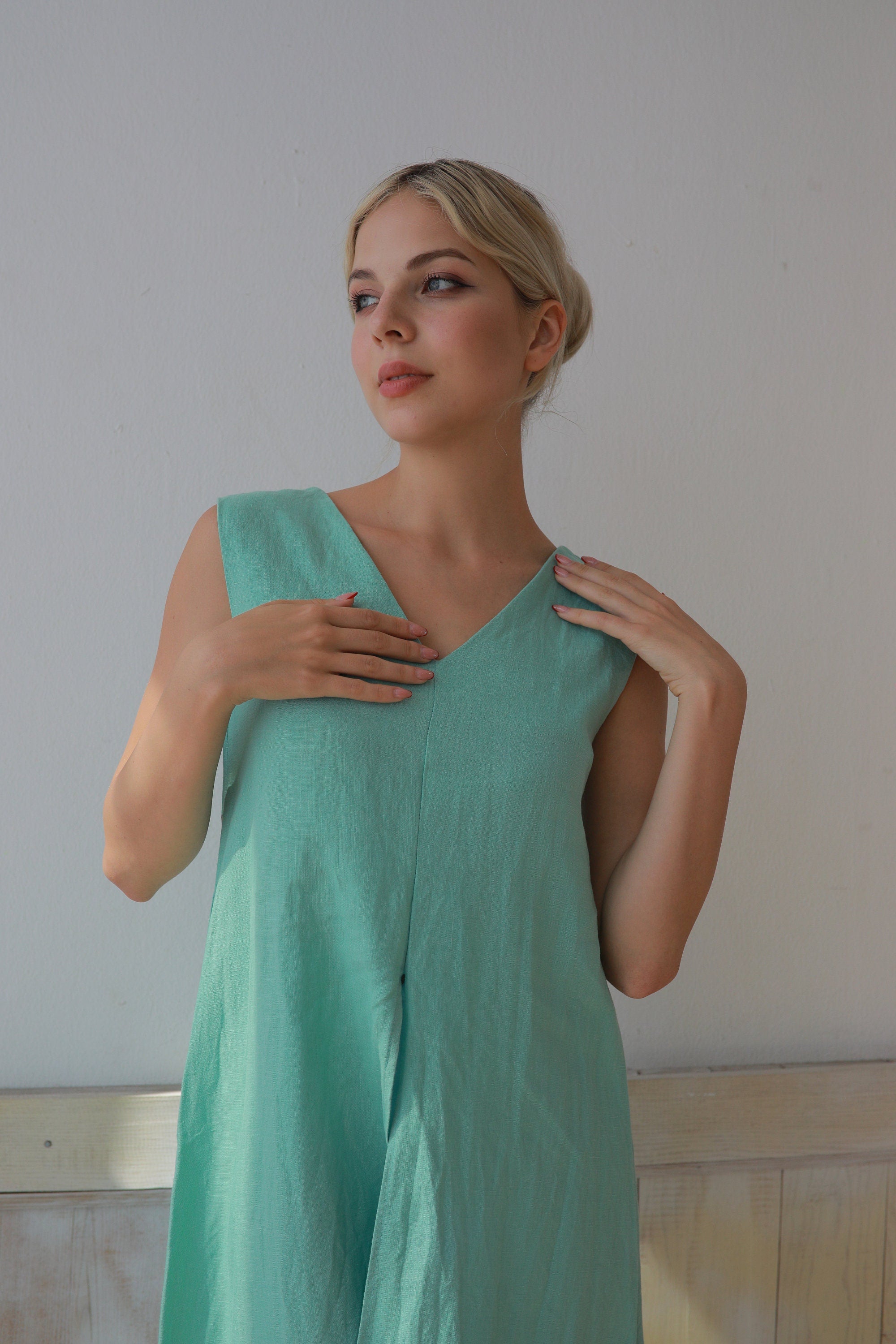 Woman wearing a light green dress against a plain background