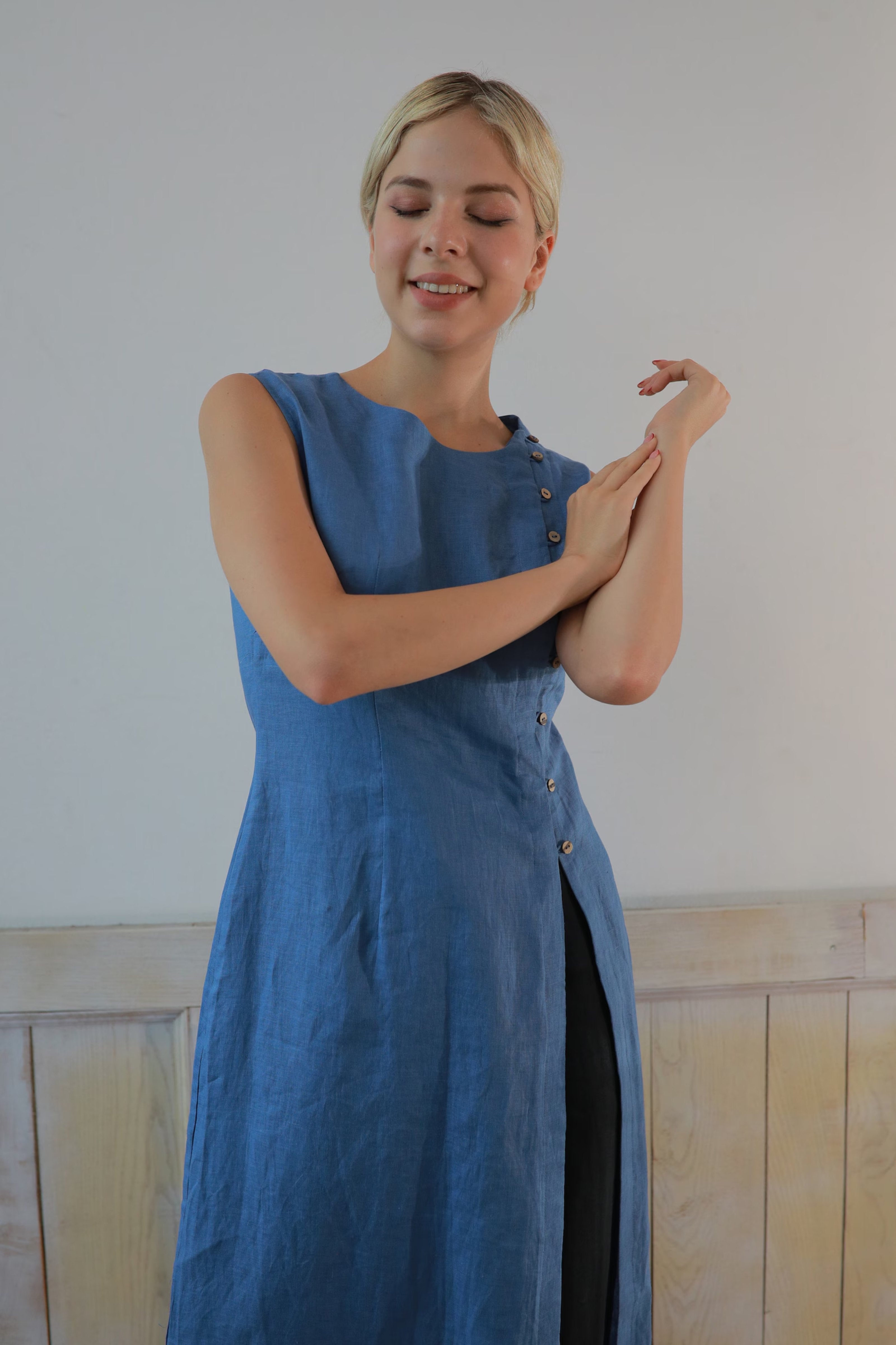 Woman wearing a blue dress standing against a plain background