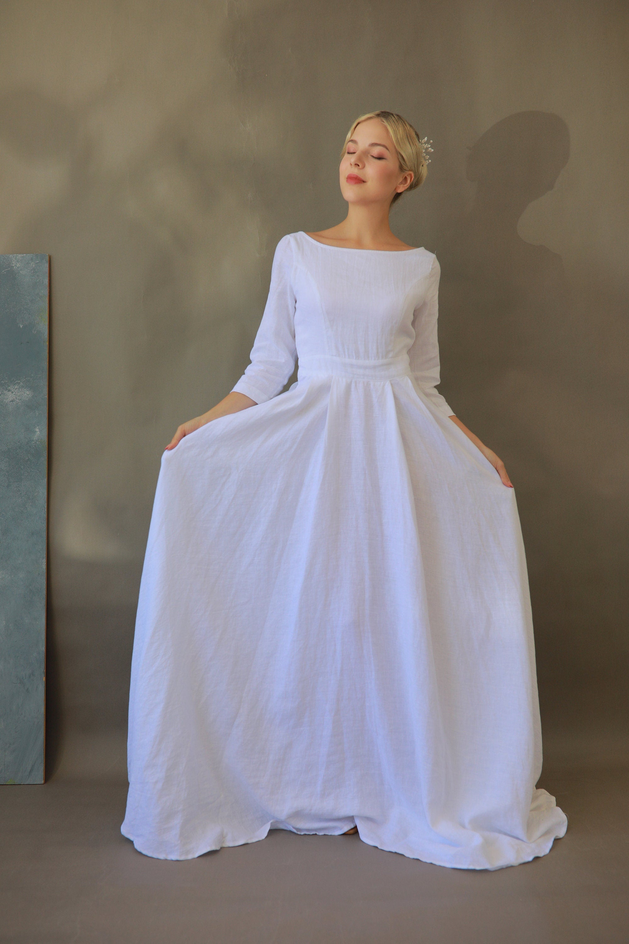 Woman wearing a white wedding dress against a plain background