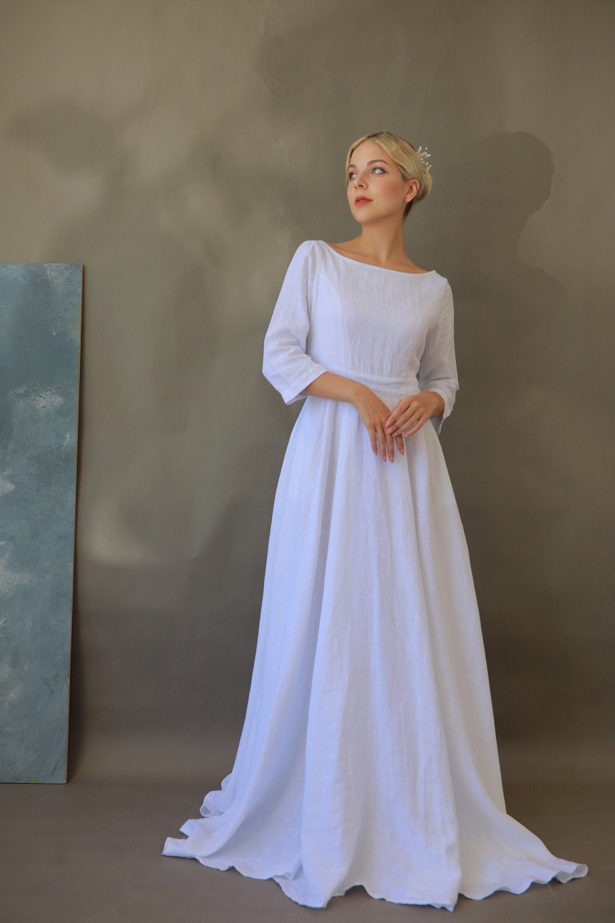 Woman wearing a white dress against a plain background