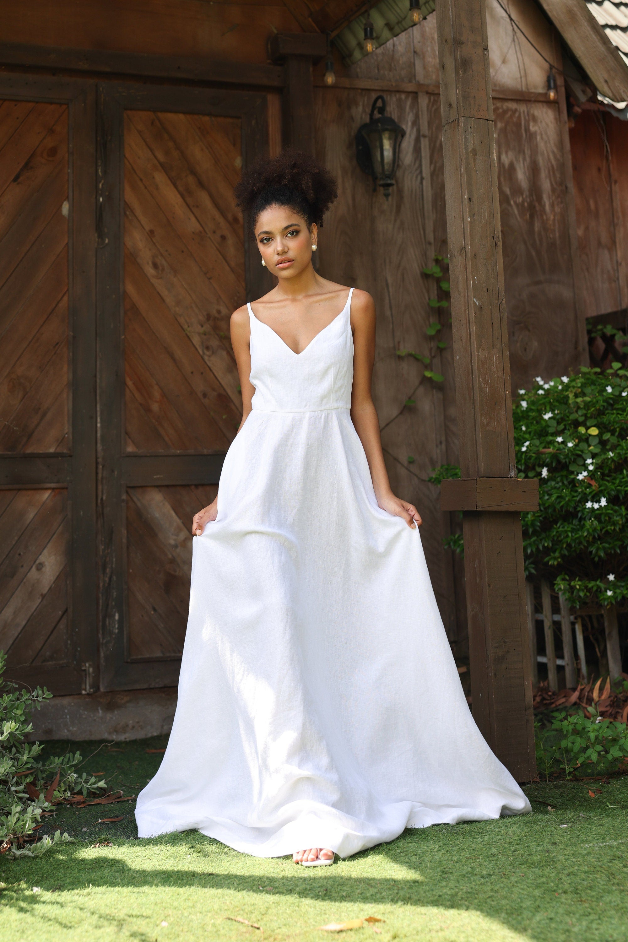 Woman in a white wedding dress standing in front of wooden doors.