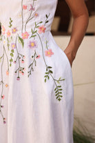 White dress with floral embroidery on a blurred background