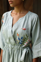 Light blue dress with floral embroidery on a blurred background