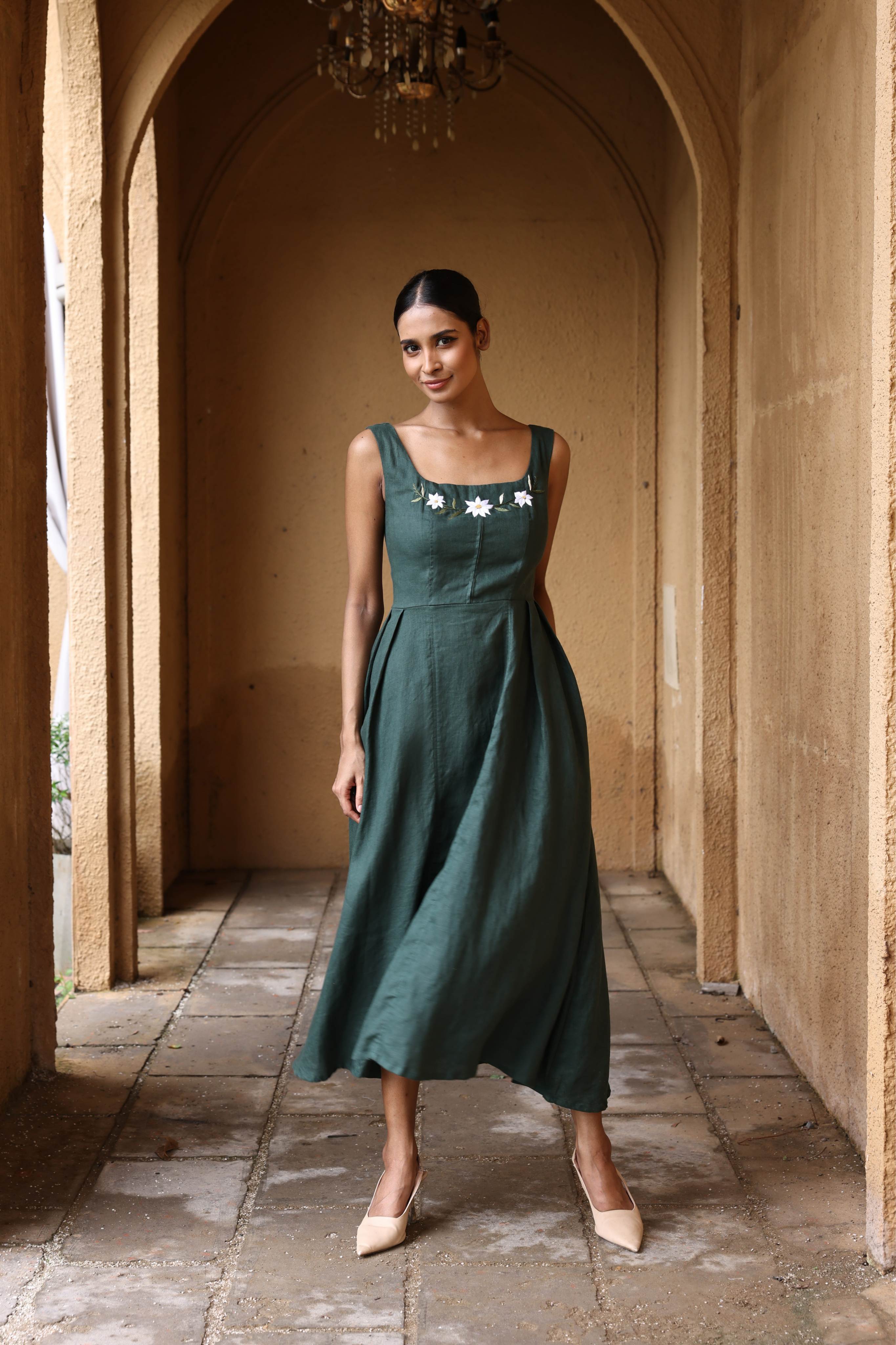 Woman in a green dress standing in an arched hallway