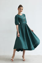 Woman wearing a green dress with floral embroidery on a white background