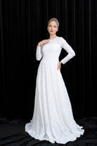 Woman wearing a white wedding dress against a black background