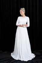 Woman wearing a white wedding dress against a black background