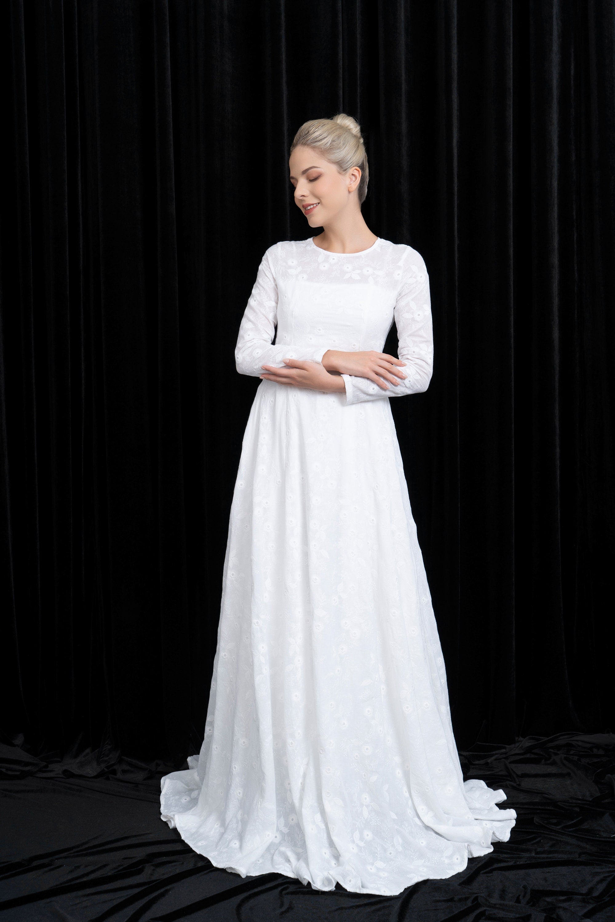 Woman wearing a white wedding dress against a black background
