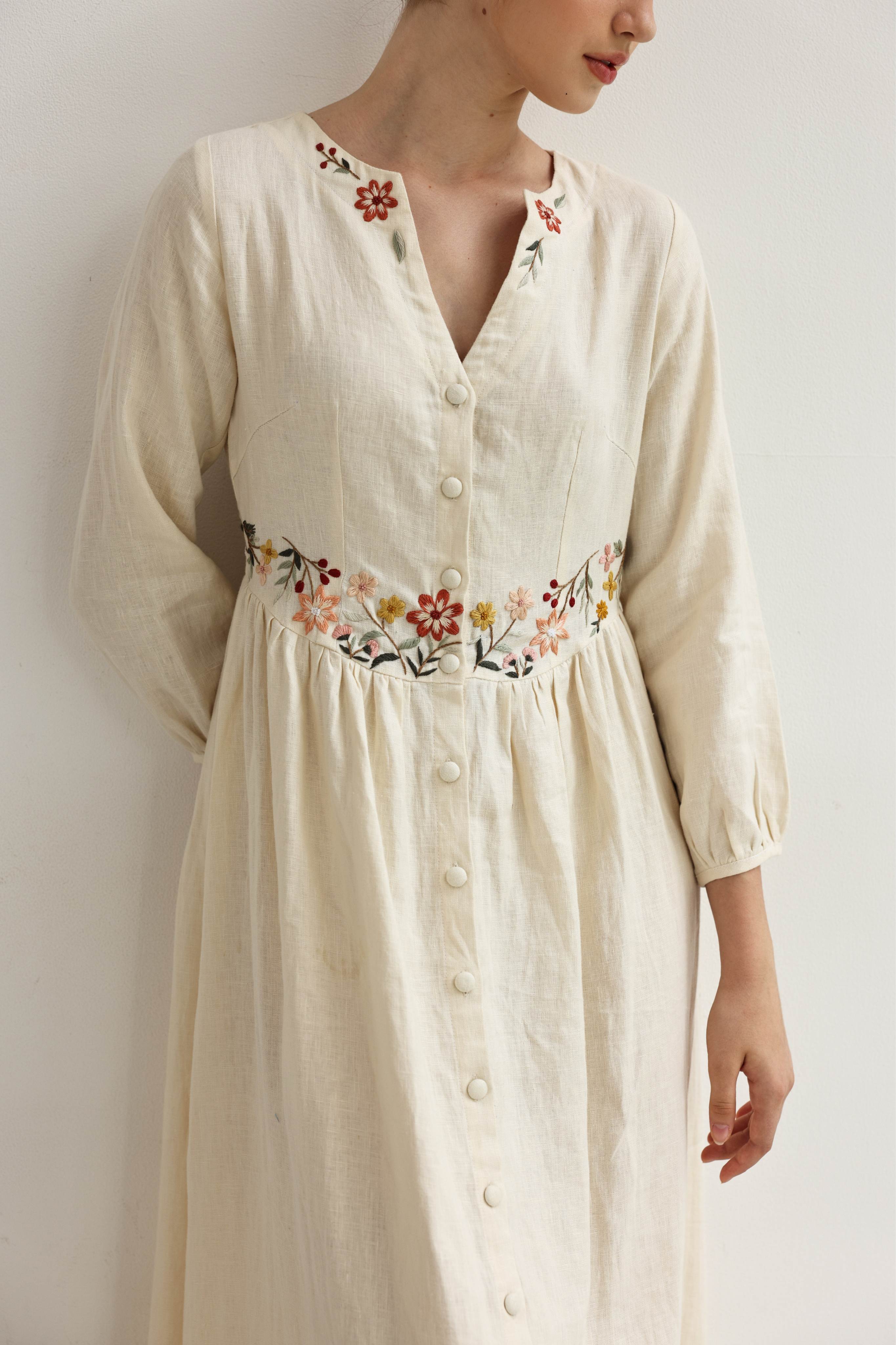 Beige dress with floral embroidery on a plain background