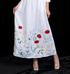 White dress with floral embroidery on a black background