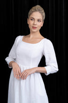 Woman wearing a white dress with a black background
