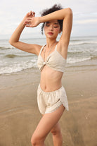 Woman in a beige bikini standing on a beach