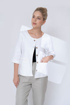 Woman wearing a white jacket with a plain background