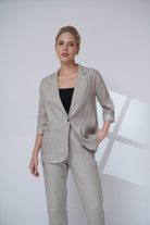 Woman wearing a suit with a black top against a white background