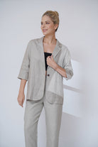 Woman wearing a light gray suit against a white background