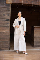 Woman in a beige suit standing in a wooden interior setting