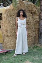 Woman in a white outfit standing in front of hay bales