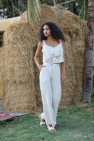 Woman in a white outfit standing in front of hay bales