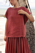 Person wearing a red outfit standing against a natural background
