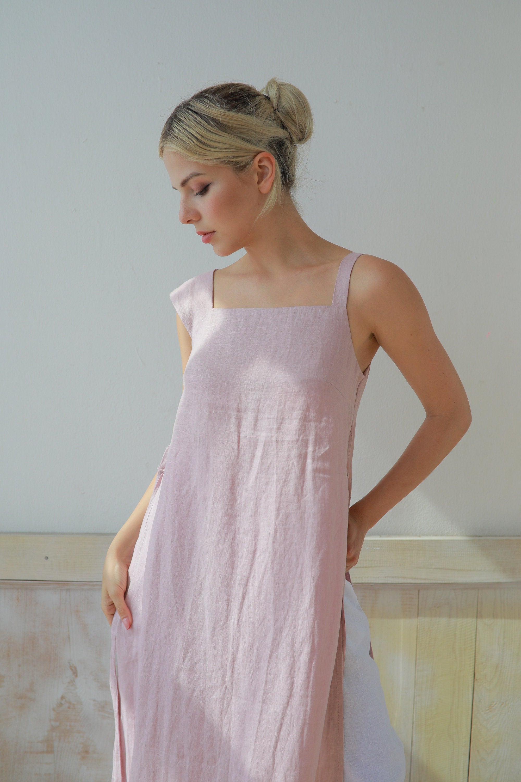 Woman wearing a light pink dress against a plain background