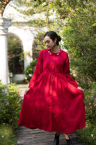 Woman in a red dress standing in a garden