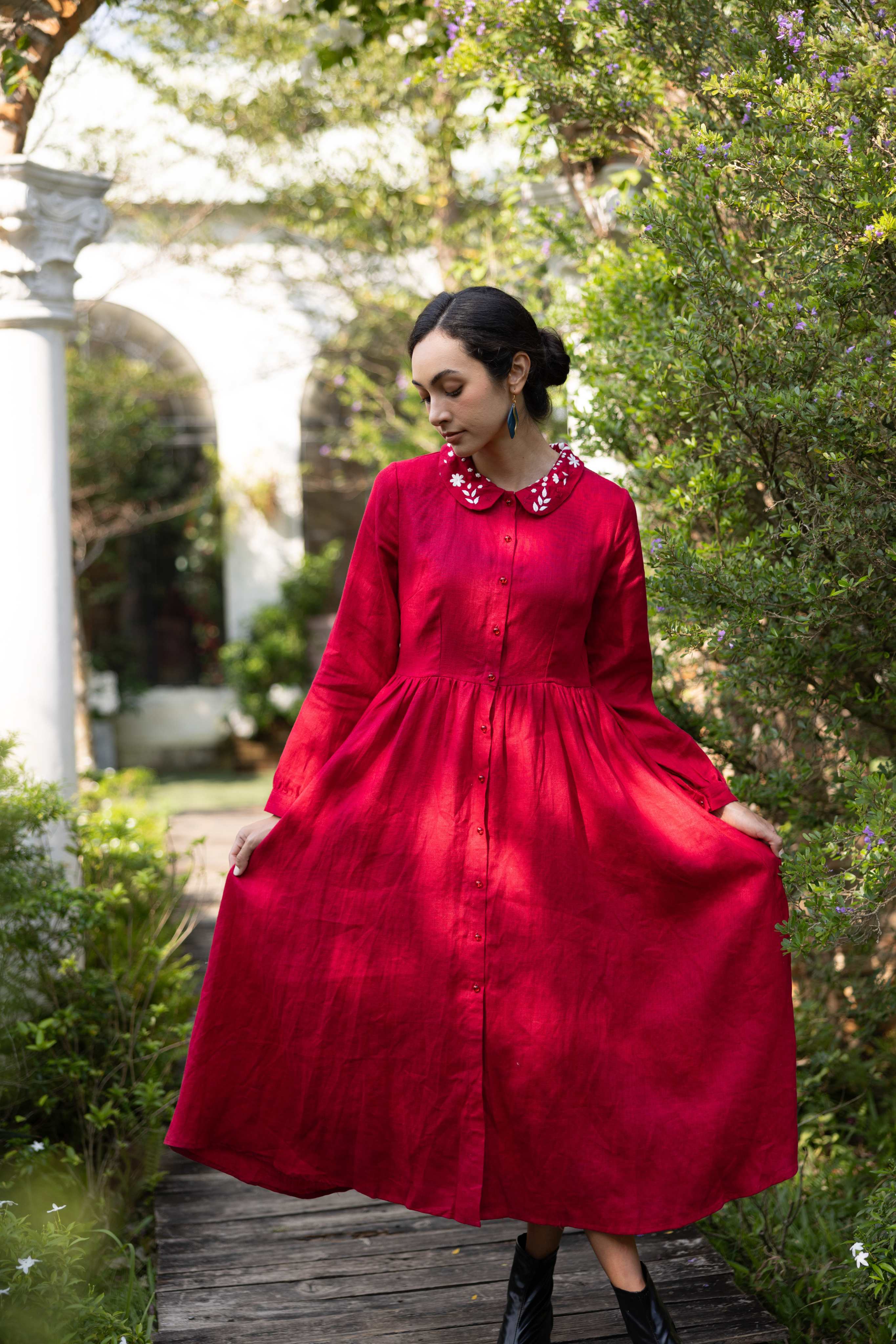 Woman in a red dress standing in a garden