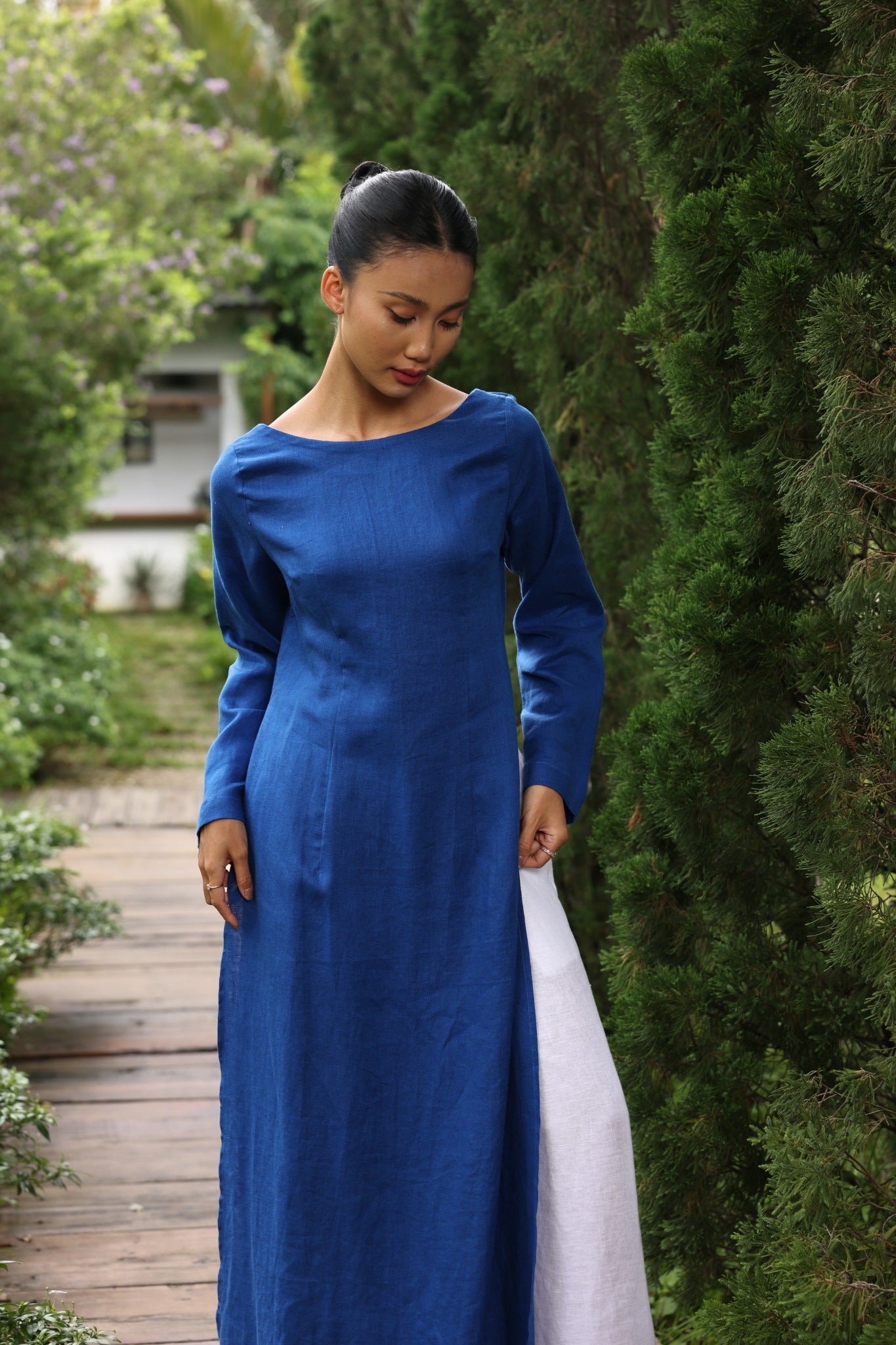 Woman in a blue dress standing in a garden