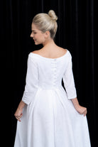 Woman wearing a white dress with a black background