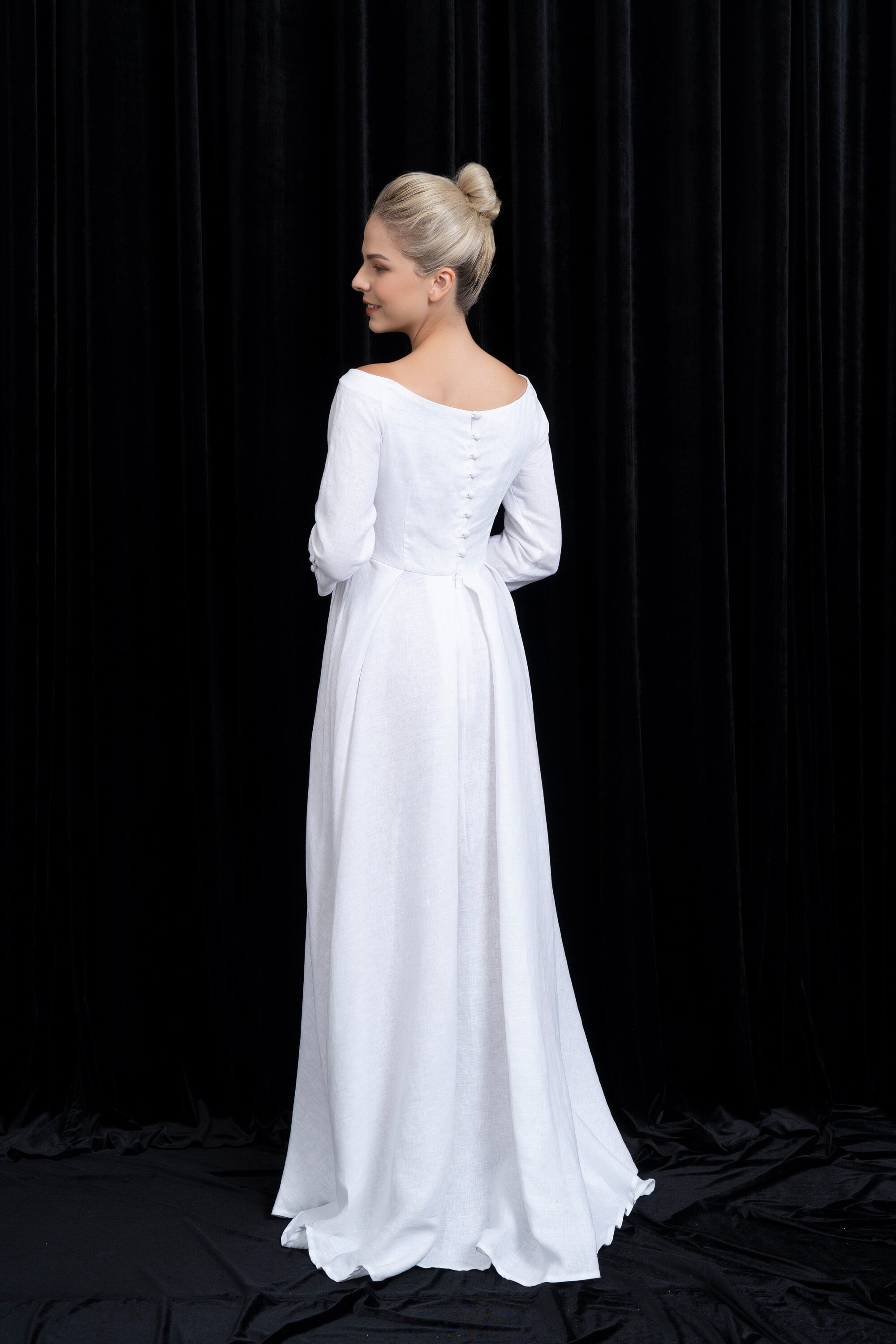 Woman wearing a white wedding dress against a black background