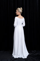 Woman wearing a white wedding dress against a black background