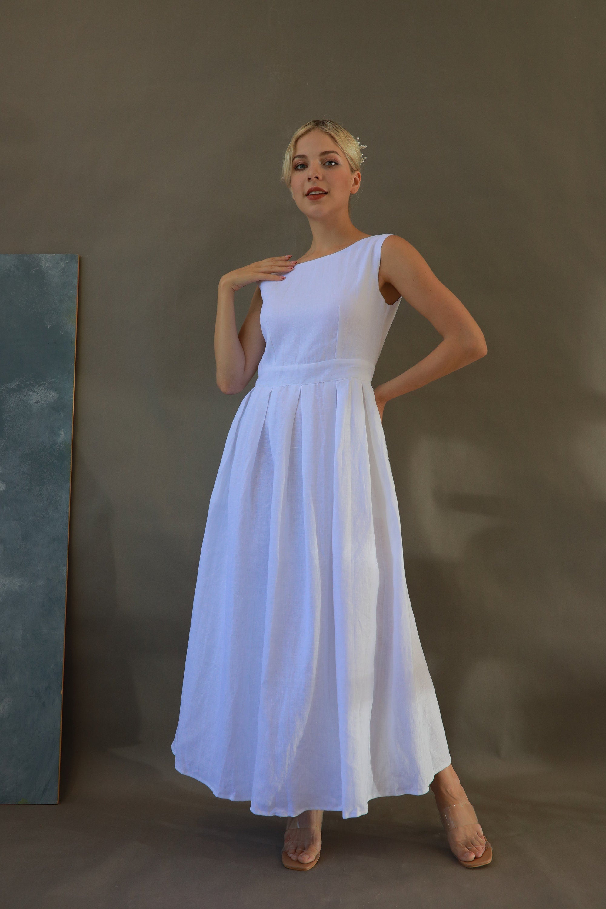Woman wearing a white dress against a plain background