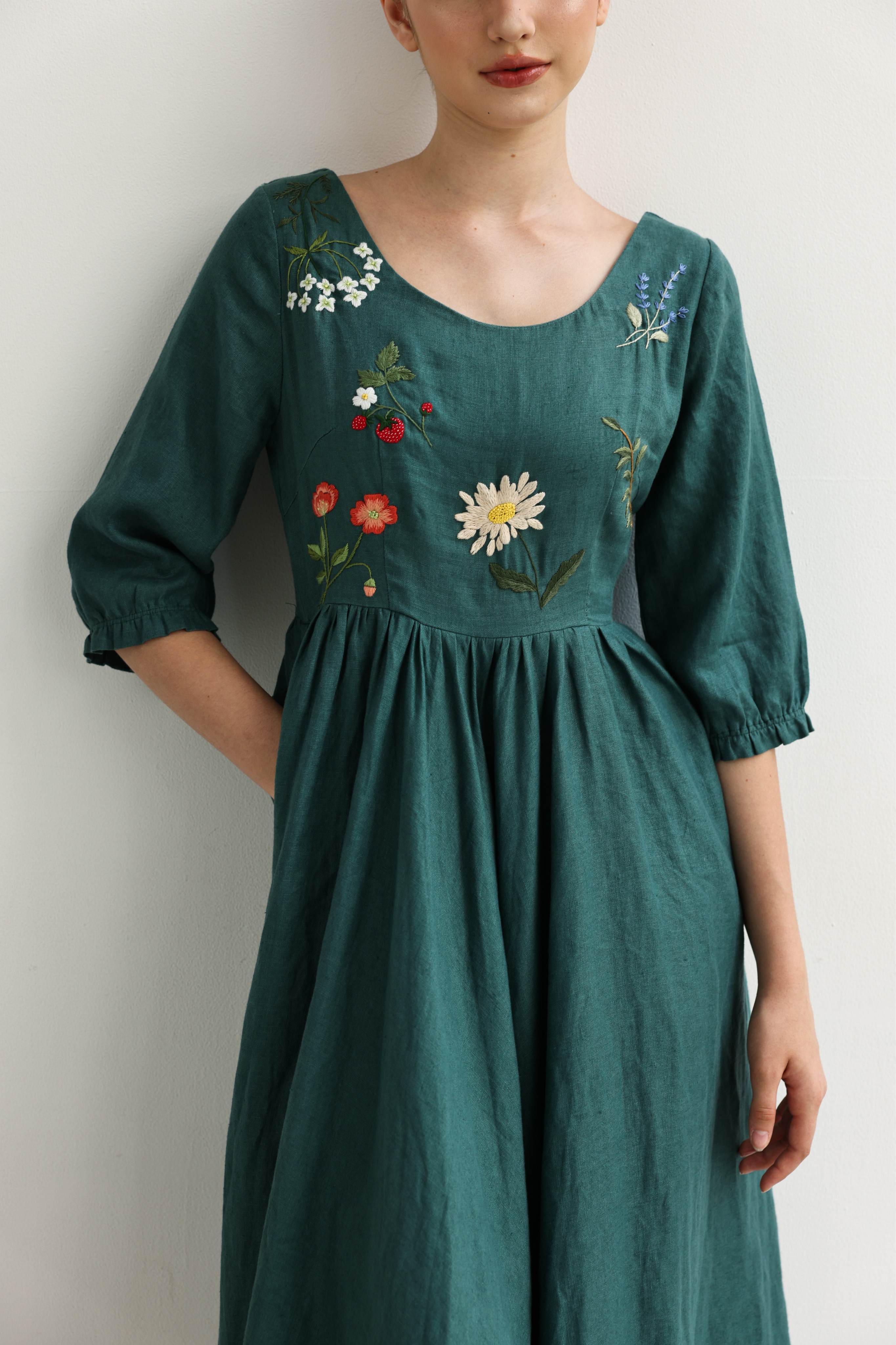 Green dress with floral embroidery on a plain background