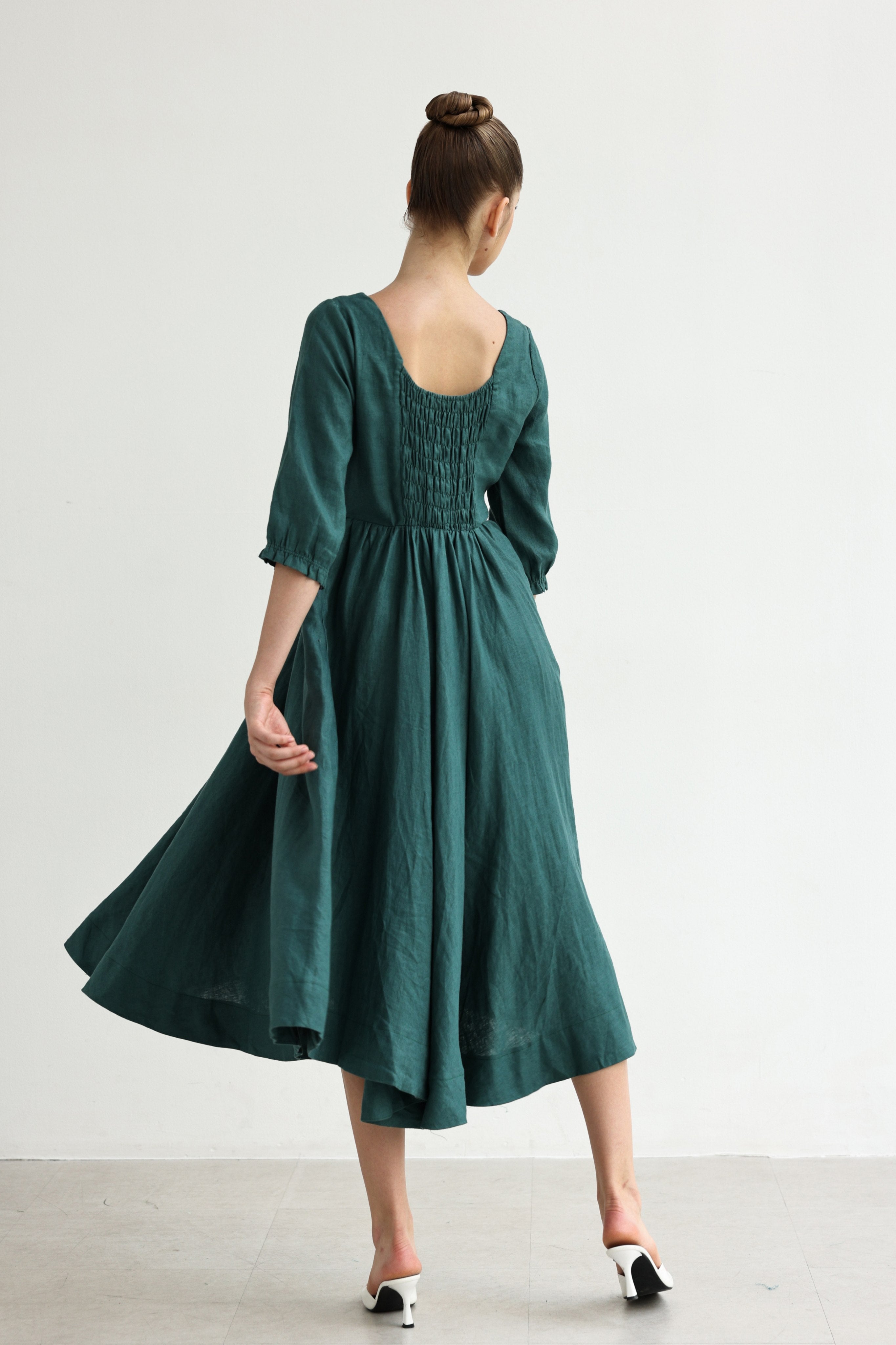 Woman wearing a green dress with a plain background