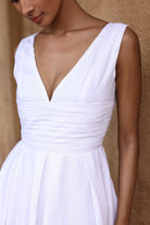 White dress with a deep neckline on a neutral background