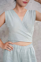 Light blue sleeveless top worn by a person on a neutral background