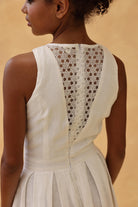 White dress with lace detailing on a beige background