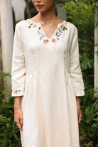 Woman wearing a dress with floral embroidery in an outdoor setting