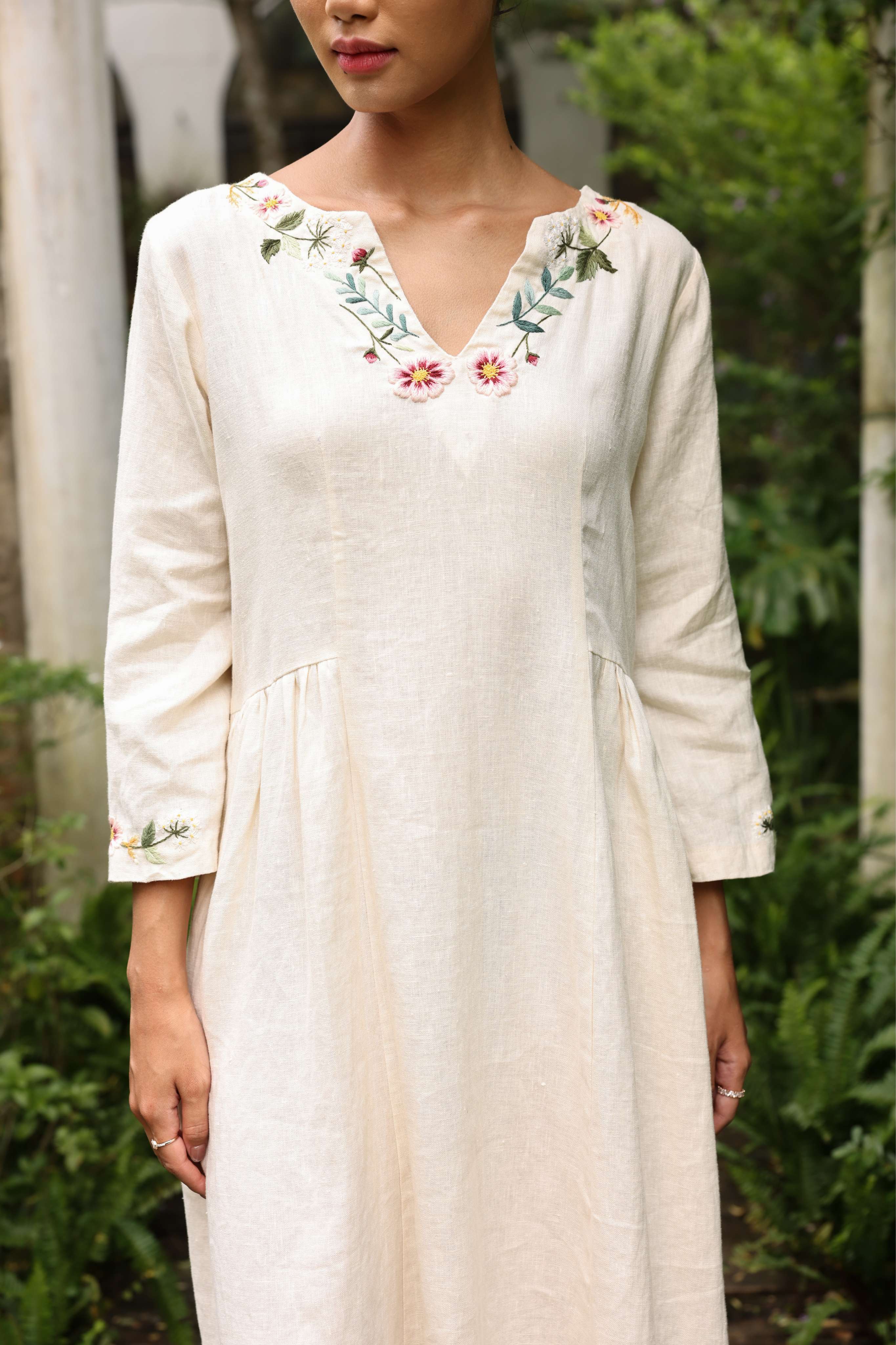 Woman wearing a dress with floral embroidery in an outdoor setting