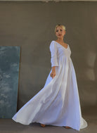 Woman wearing a white dress against a plain background